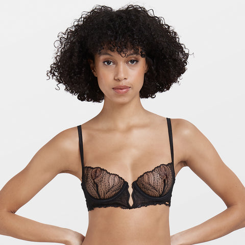 Model wearing Irena black bra with sheer embroidered mesh cups and underwire support.